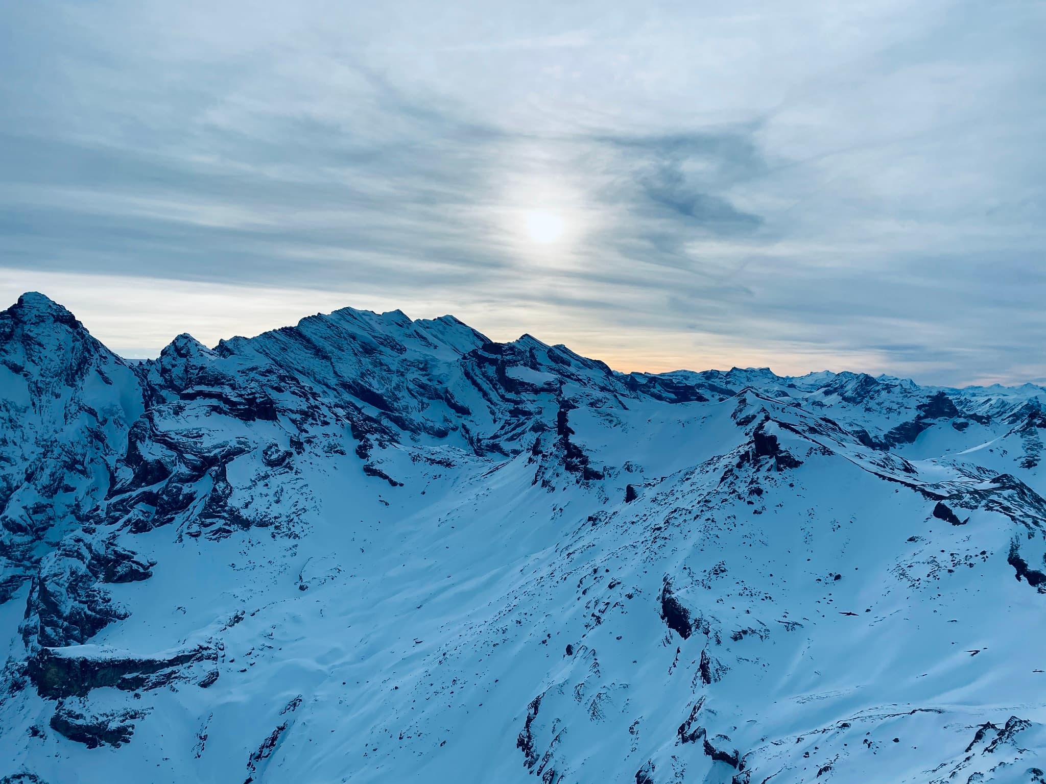 Snow-covered alpine peaks at dusk